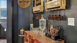 A bar area with a whiskey sign, copper mugs, and a glassware display. - Tennessee Whiskey Lounge on Music Row - sleeps 6 (Nashville)