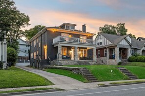 A two-story house with a balcony, stone foundation, and a driveway leading to the front door. - Tennessee Whiskey Lounge on Music Row - sleeps 6 (Nashville)