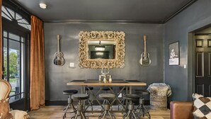 A dining area with a large mirror, bar stools, and a table. - Tennessee Whiskey Lounge on Music Row - sleeps 6 (Nashville)
