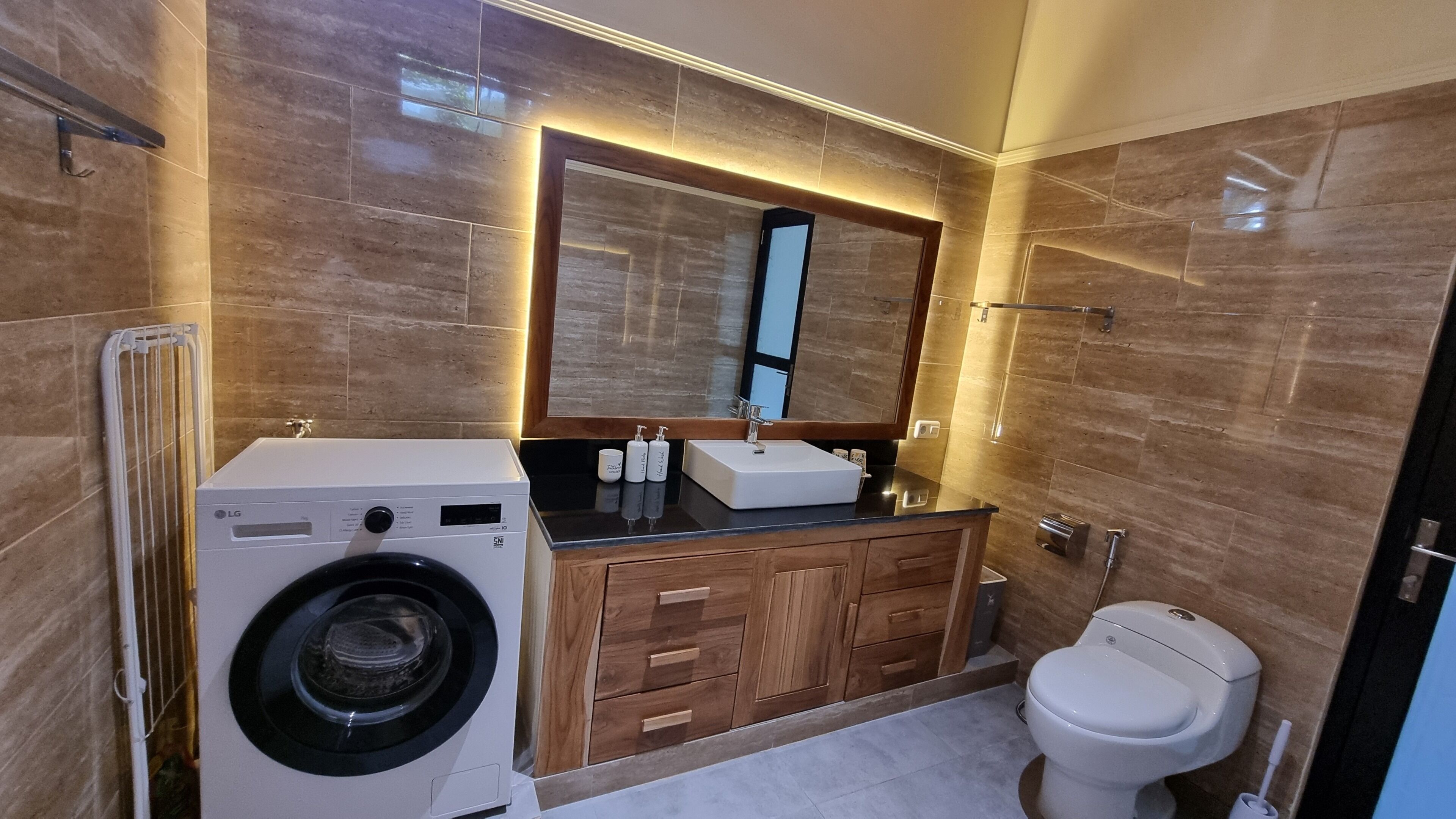 Un baño moderno con lavadora, lavamanos e inodoro.