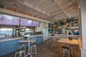 A restaurant interior with a counter, menu boards, and a wall of photographs. - Steps to Sapphire's Sandy Beach - D12 Crystal Cove - Sapphire Bay West (St Thomas)