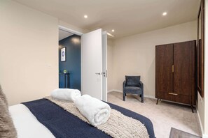 Ein Schlafzimmer mit einem Bett, einem Sessel und einem Kleiderschrank.