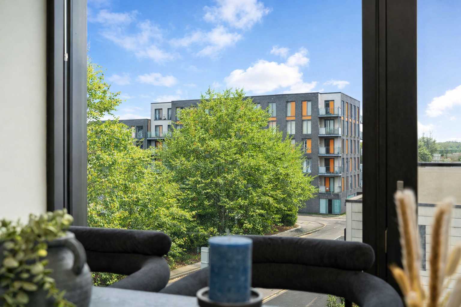 A modern building with balconies and a clear view of the surrounding greenery.