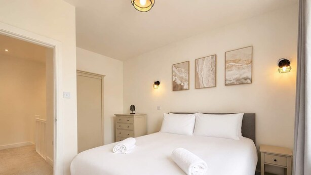 A hotel room with a bed, bedside tables, and artwork on the wall. - Beautiful House 2BR - Sleeps 6 - Free Parking - Huddersfield (Huddersfield)