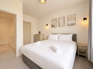 Ein Hotelzimmer mit einem Bett, Nachttischen und Kunstwerken an der Wand.