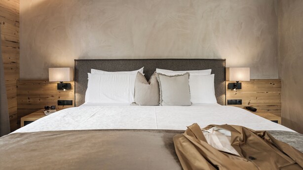 A modern hotel room with a large bed, two bedside tables, and a headboard. - Hotel Bergkristall Zillertal-Adults Only (Hippach)