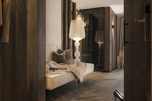 Un dormitorio moderno con una cama grande, una lámpara decorativa y suelo de madera.