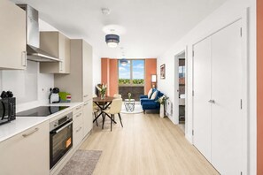 Eine moderne Küche mit Essbereich, einer Couch und Blick ins Freie.