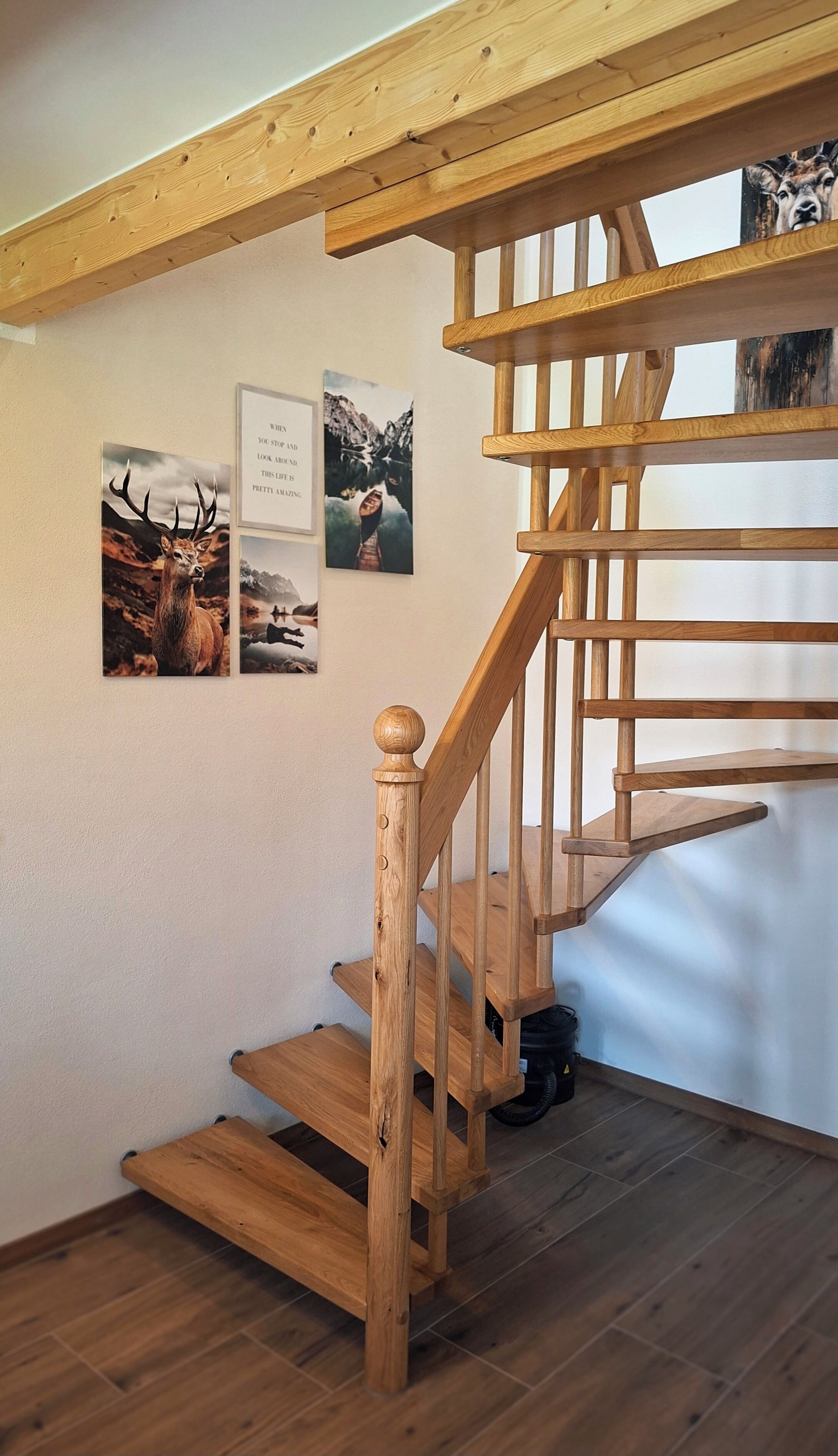 Eine Holztreppe mit Handlauf und einem an der Wand befestigten Bilderrahmen.