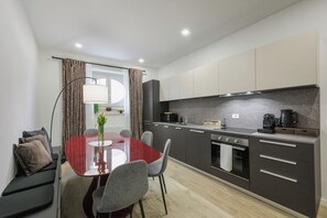 A compact kitchen with a dining area, modern appliances, and a view to the outside. - Bologna Historic Center: Spacious 4-Bedroom, 4-Bathroom Home (Bologna)