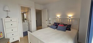 A bedroom with a bed, bedside tables, a dresser, and a mirror. - 
Exclusive semi-detached house, at short distance from the beach and local shops (Calahonda)