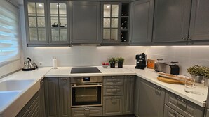 Een moderne keuken met roestvrijstalen apparatuur, een inbouwoven en een koffiezetapparaat.