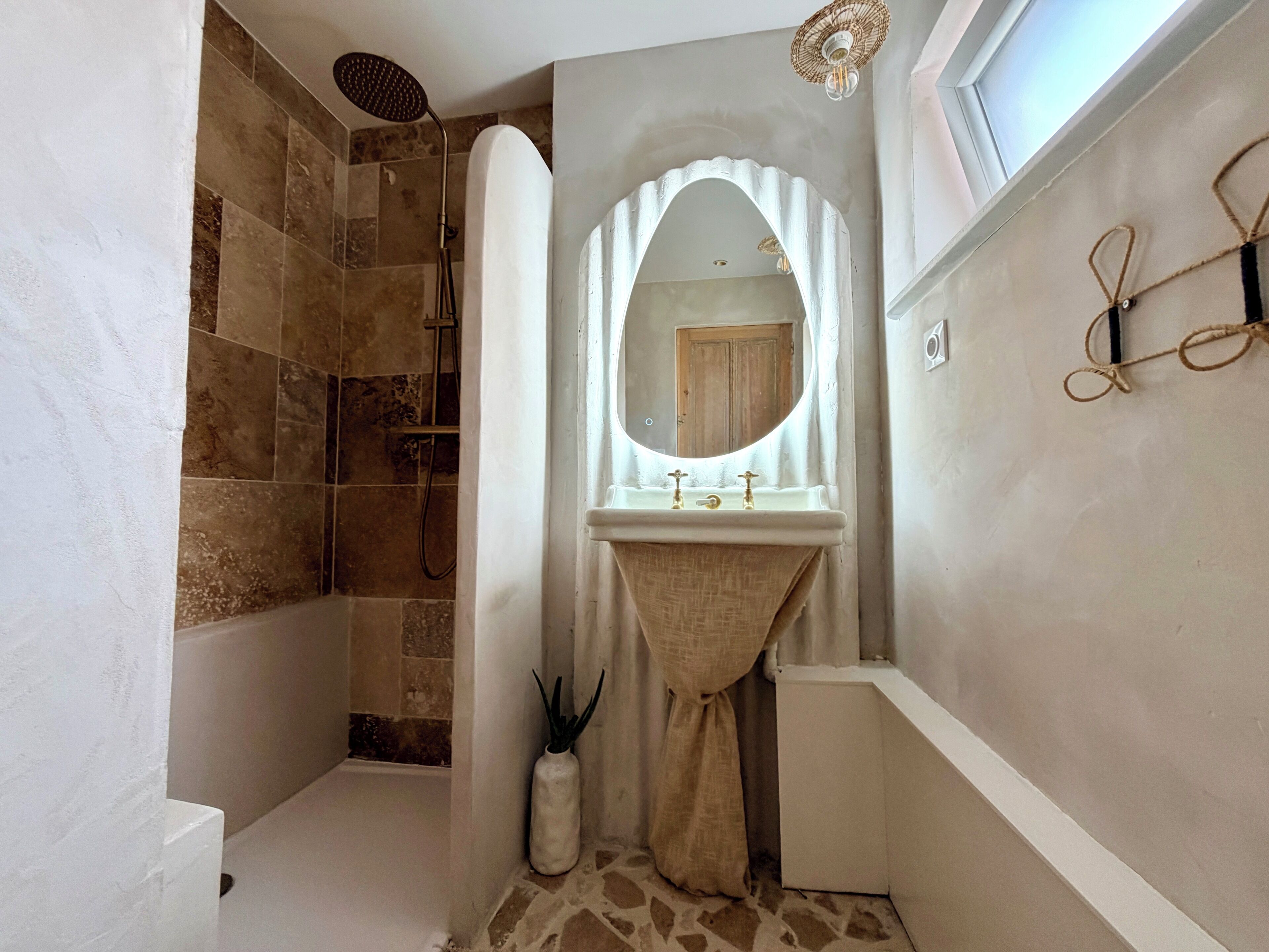 Ein Badezimmer mit Dusche, Waschbecken und Spiegel.