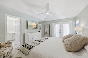 A bedroom with a bed, a ceiling fan, a TV, and a door. - BRAND NEW Saltwater POOL w/Spa. Waterfalls. Totally Renovated Exceptional OASIS! (Naples)