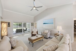 A spacious living room with a ceiling fan, a large window, and a view of the outdoors. - BRAND NEW Saltwater POOL w/Spa. Waterfalls. Totally Renovated Exceptional OASIS! (Naples)