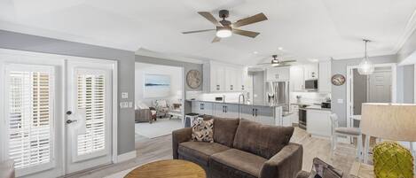 Un salon moderne avec un canapé, une table basse et un ventilateur de plafond.