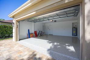 Eine Garage mit freiem Durchgang, einem Warmwasserbereiter und dort abgestellten Fahrrädern.