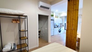 A bedroom with a bunk bed, a wooden shelf, and an air conditioning unit.