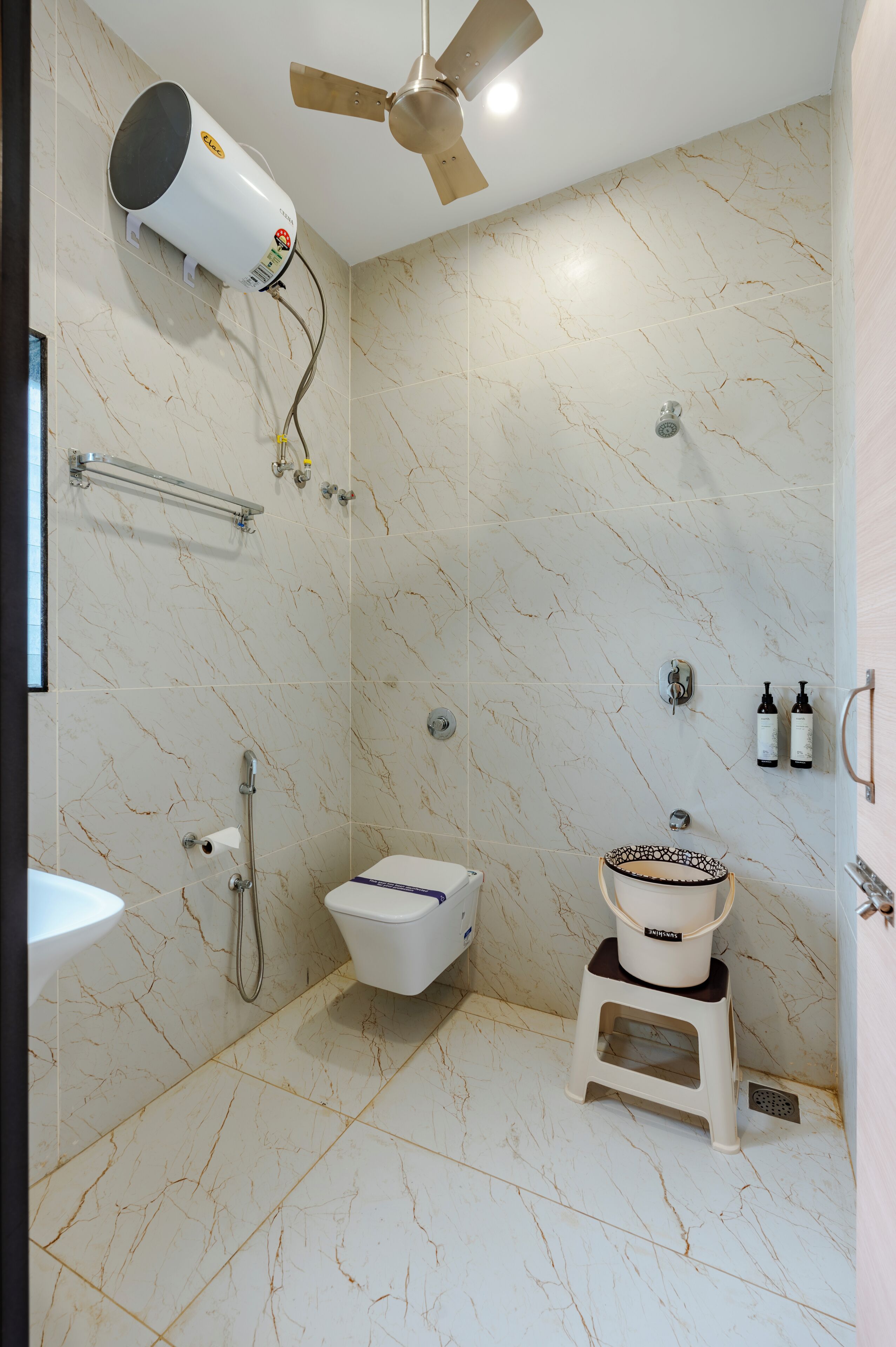 Un baño con ventilador de techo, inodoro, lavamanos y ducha.