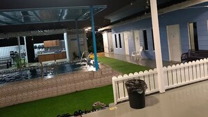 An outdoor area with a pool, a white picket fence, and a covered seating area. - Hotel O D Longan Cottage (Sungai Petani)