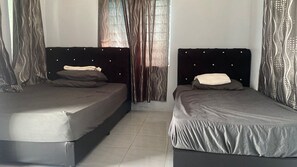 A room with two beds, each with a headboard and pillows, and a window with curtains. - Hotel O D Longan Cottage (Sungai Petani)