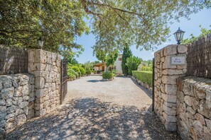 A stone gate leading to a building with a gravel path. - Countryside Villa in Pollensa (Pollença)