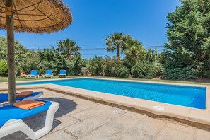 A swimming pool with lounge chairs and a thatched umbrella. - Countryside Villa in Pollensa (Pollença)