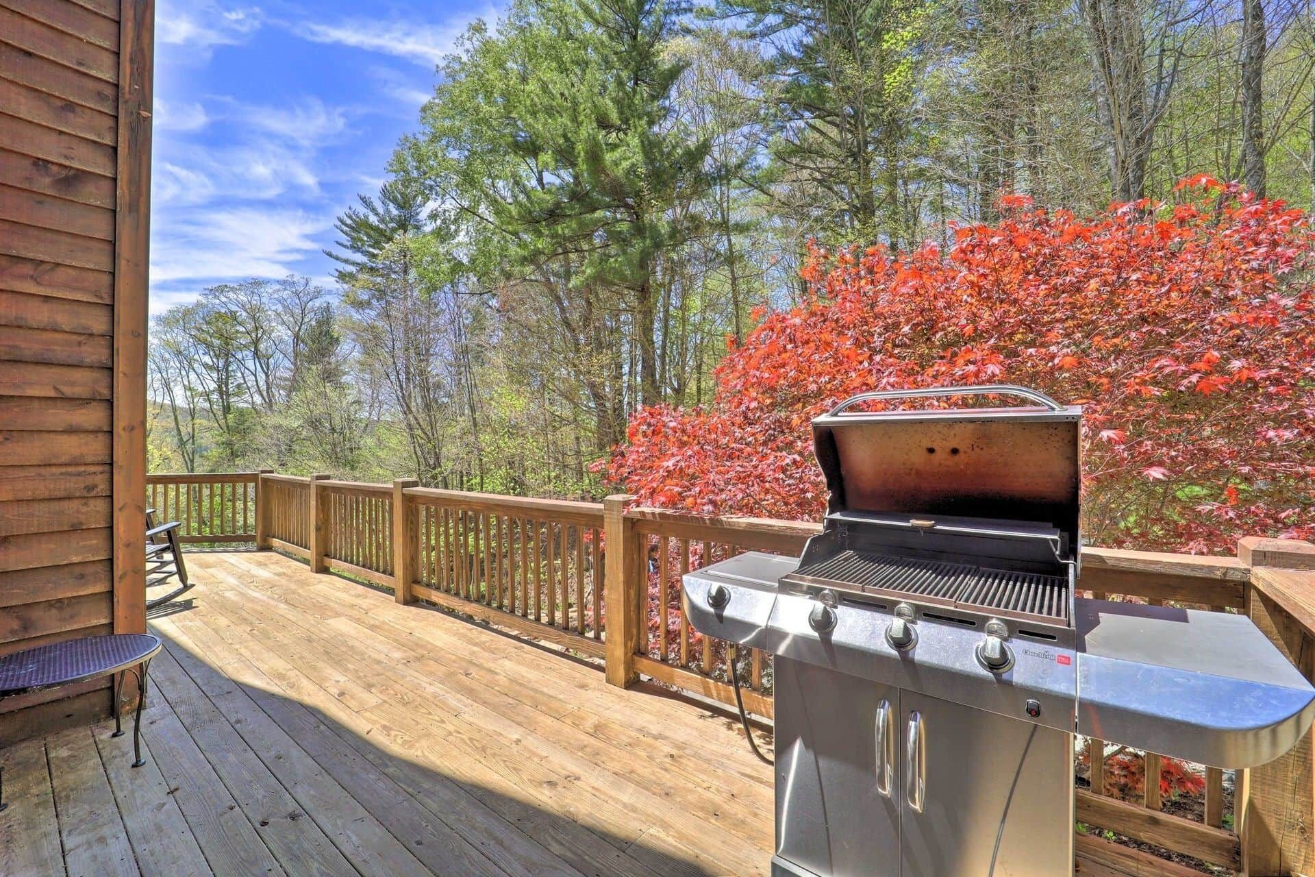 Eine Holzterrasse mit Grill und Sitzbank.