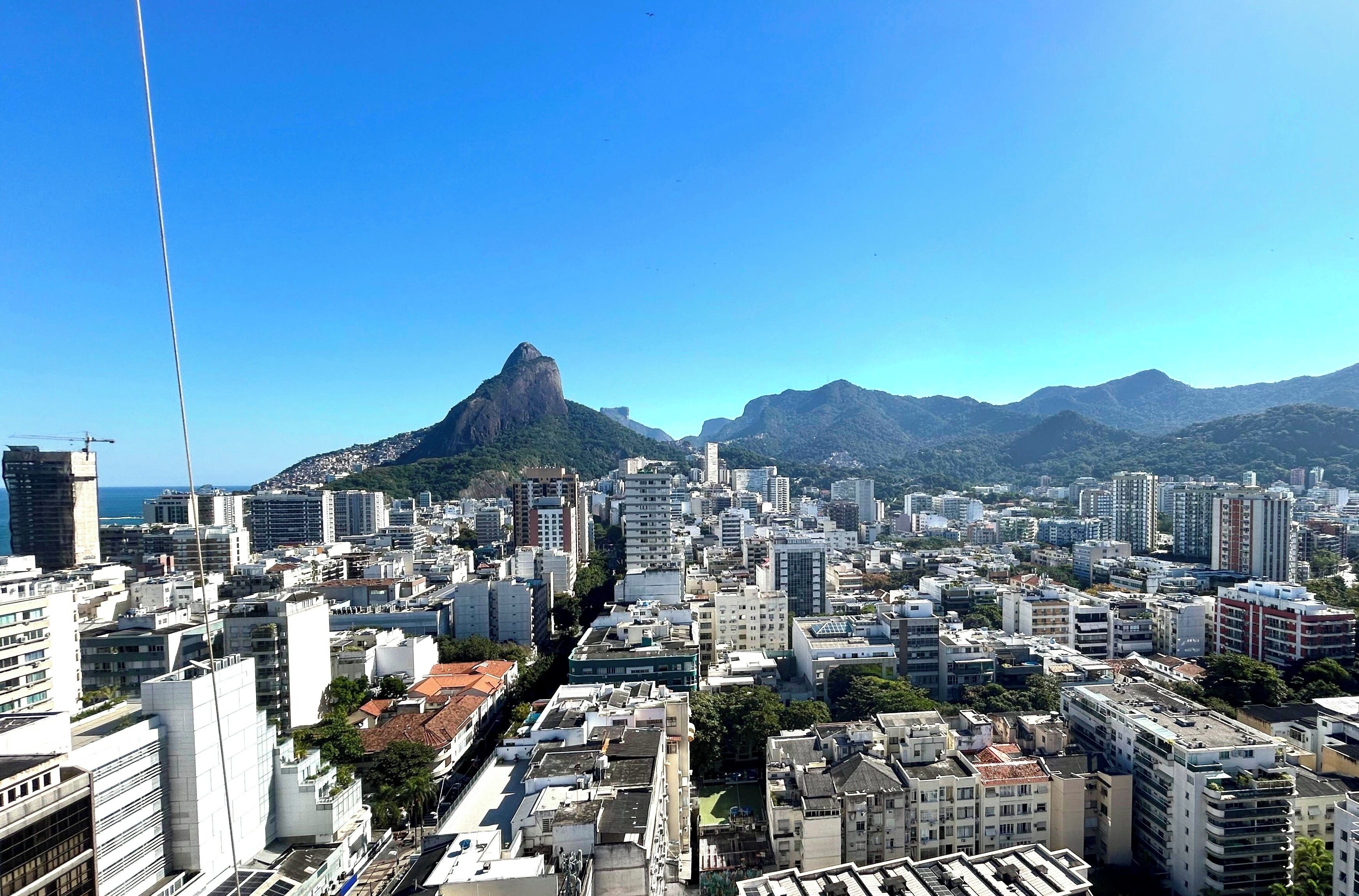 A cityscape with a prominent mountain peak in the background.