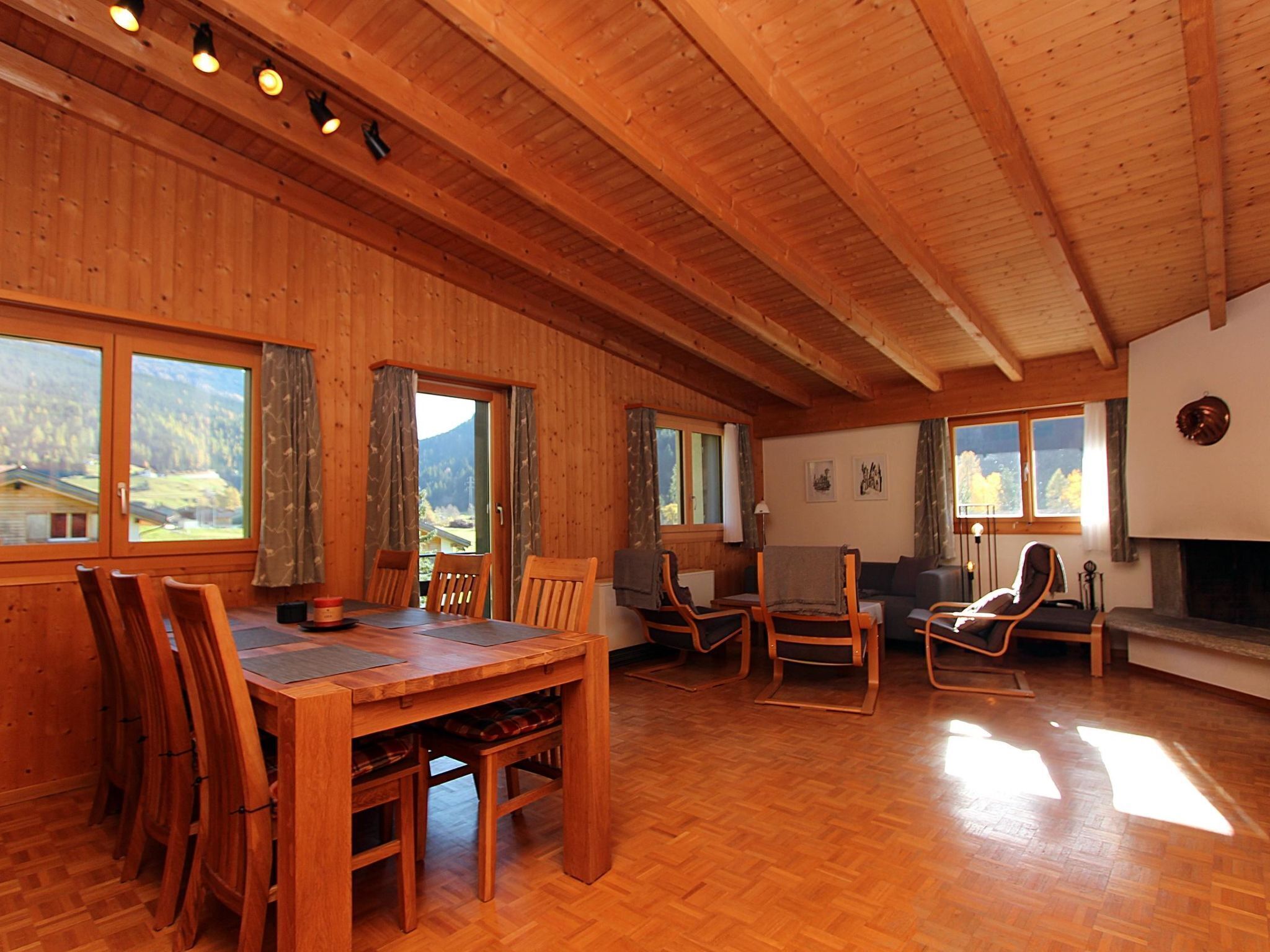 Un intérieur en bois comprenant une table à manger, des chaises, un canapé et une cheminée.