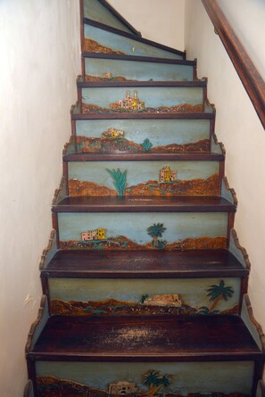Uma escadaria com degraus pintados retratando uma cena de paisagem.