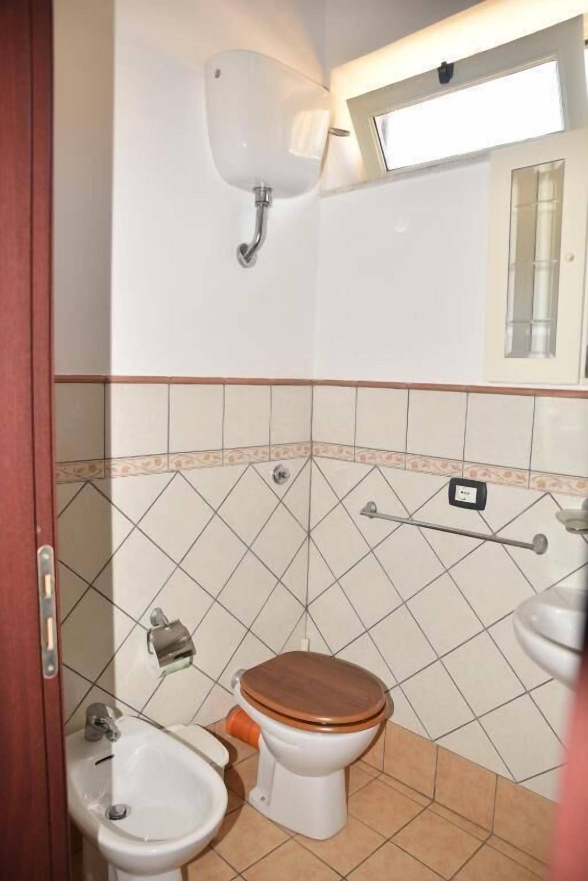 Ein Badezimmer mit Toilette, Bidet und Waschbecken.