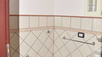 A bathroom with a toilet, sink, and a window above the sink.