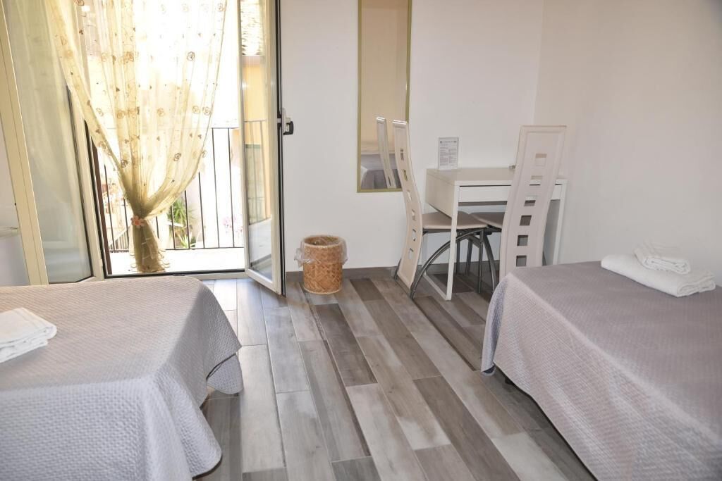 Habitació d'hotel amb dos llits, una taula i una cadira.