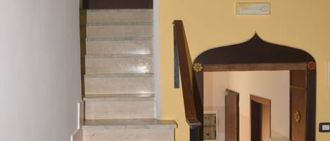 A staircase with a handrail leading to a door.