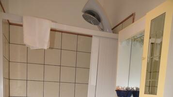 Ein Badezimmer mit Dusche, Waschbecken und Spiegel.