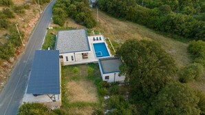 Il s’agit d’une propriété résidentielle dotée d’une piscine, d’un patio couvert et bordée par une route.