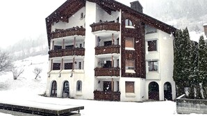 A multi-story building with balconies, set in a snowy landscape. - Cadras 10 Appartement/Fewo, Bad, WC, 2 Schlafräume 3 Zimmerwohnung - 4 Betten by Interhome (Tinizong)
