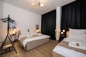 Hotellihuoneessa on kaksi sänkyä, työpöytä ja tuoli. Sängyn vieressä on yöpöydät, joissa on lamput ja peili. Huoneessa on puulattia ja yhdessä ikkunassa musta verho.
