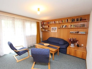 A cozy living room with a sofa, two armchairs, a coffee table, and a bookshelf filled with books. - Las Vals B5 Appartement/Fewo, Bad, WC, 2 Schlafräume 3 Zimmerwohnung - 5 Betten by Interhome (Savognin)