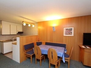 A compact kitchen with a dining area featuring a table and four chairs. - Las Vals B5 Appartement/Fewo, Bad, WC, 2 Schlafräume 3 Zimmerwohnung - 5 Betten by Interhome (Savognin)