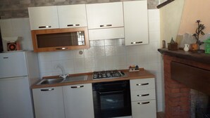 A compact kitchen with white cabinets, a microwave, a gas stove, and a dishwasher. - A cool, comfortable, and beautiful apartment (Aritzo)