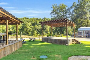 A covered outdoor area with picnic tables and a wooden deck.