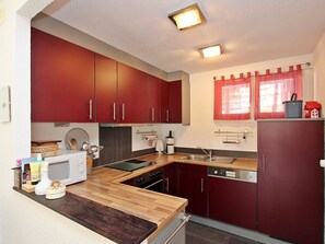 A compact kitchen with wooden countertops, a built-in oven, and a sink. - Las Vals E03 Appartement/Fewo, Dusche, WC, 2 Schlafräume by Interhome (Savognin)