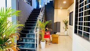 Een modern interieur met een trap, potplanten en een houten bank.