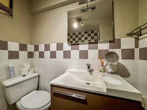 A bathroom with a toilet, sink, mirror, and checkered wall tiles. - POINTE CROISETTE TERRACE STUDIO A0B214 (Cannes)