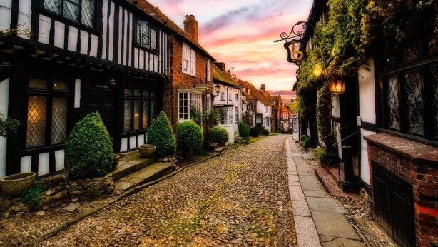 A narrow cobblestone street lined with traditional half-timbered houses, a clear sky, and a sunset. - The Nook in Rye Town Centre (East Sussex)
