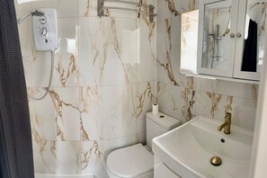 Ein Badezimmer mit Toilette, Waschbecken und Dusche.