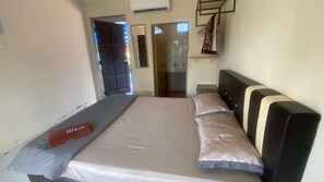 Ein Schlafzimmer mit einem Bett, einem Kopfteil und einer Tür zu einem Badezimmer.