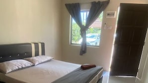 Un dormitorio con cama, ventana con cortinas, puerta y suelo de baldosas.